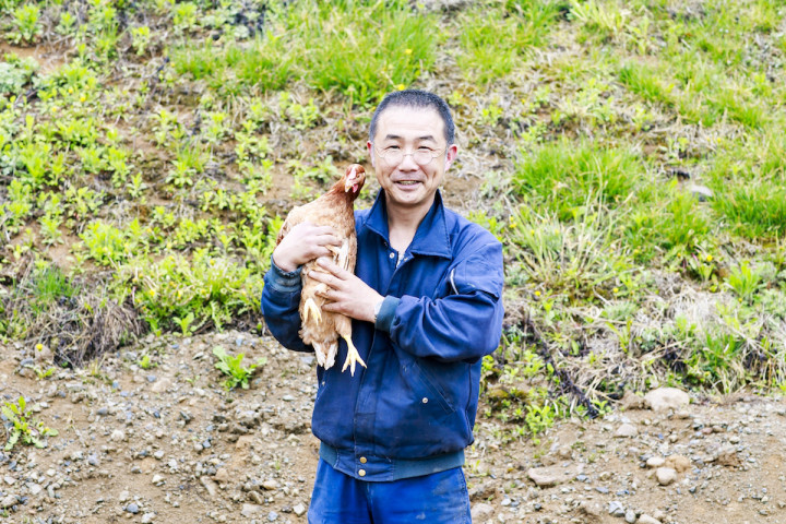 鶏を抱く佐々木工場長